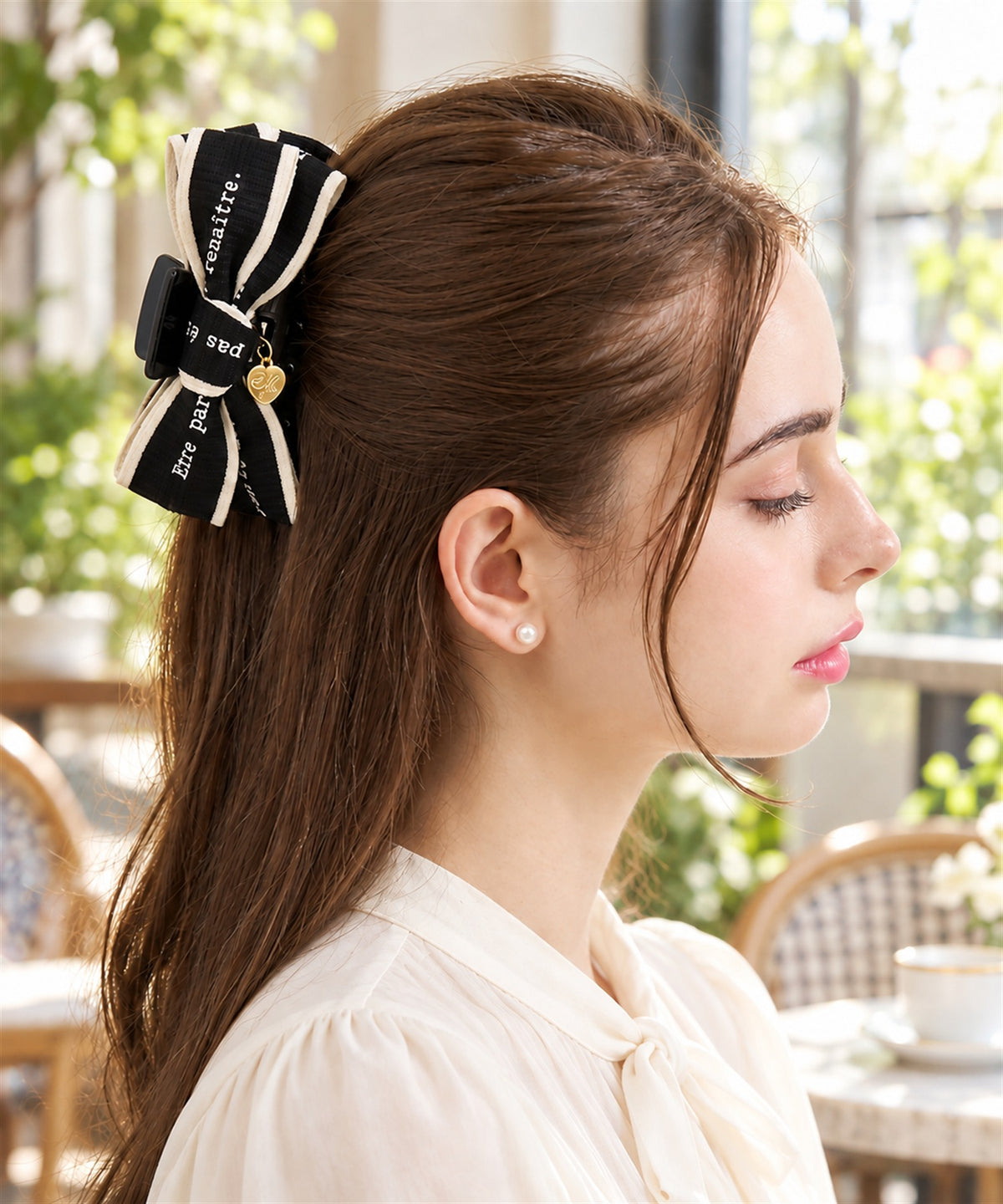 Maëlle バンスクリップ ブラック 昼のカフェでの横からの着用イメージ